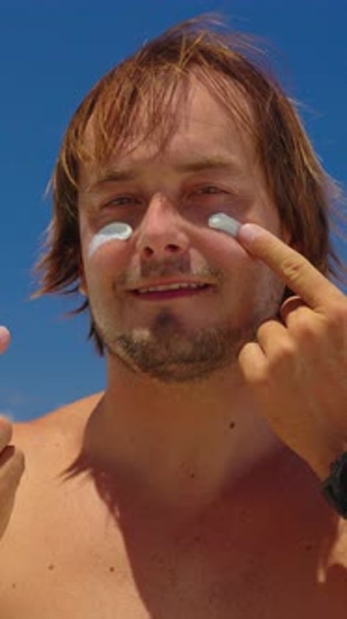 Vertical Video Closeup Man Applies Sun Cream on Face Enjoys the Sun