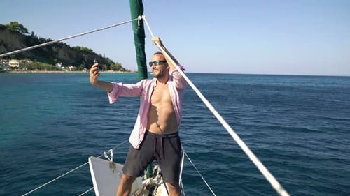 Young Man Taking Selfie Photos with Cellphone While Sailing Boat on Sea Adult