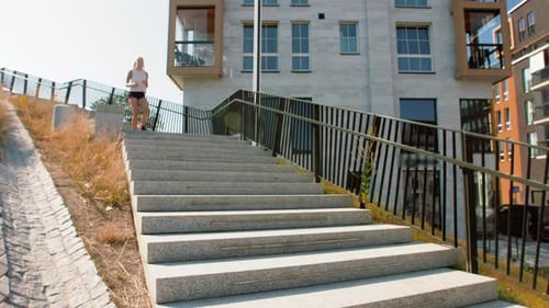 Konzept für Fitness, Sport und gesunden Lebensstil - Junge Frau rennt die Treppe hinunter