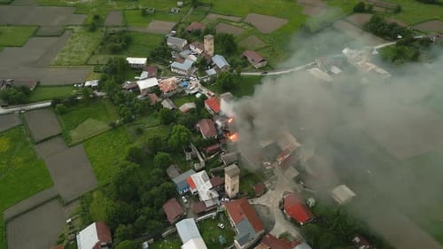 Old Stone Tower in Mestia Svaneti Mountains on Fire Thick Smoke Covers Village Firefighters Work on