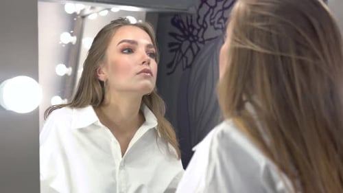 Young Woman Standing in Front of Mirror