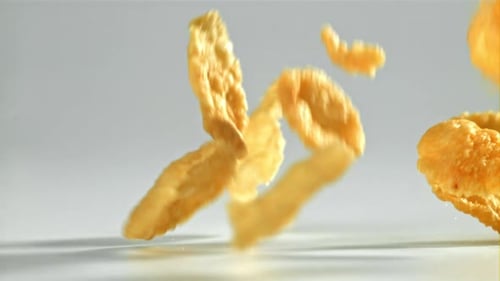 Cornflakes, die auf weißen Hintergrund fallen, gefilmt mit einer Hochgeschwindigkeitskamera mit 1000 Bildern pro Sekunde