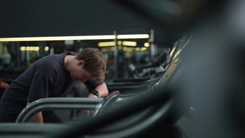 Tired Beginner Runner Sportsman Resting After Running on Treadmill During Cardio Session in Gym