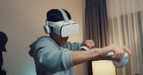 Man Plays VR Game with Headset and Controllers