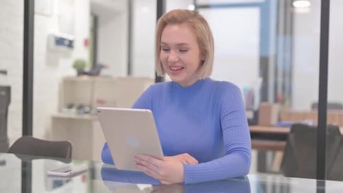 Young Woman Doing Video Chat on Tablet in Office