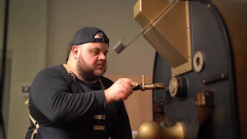 Man Inspecting Coffee Beans in Roasting Machine