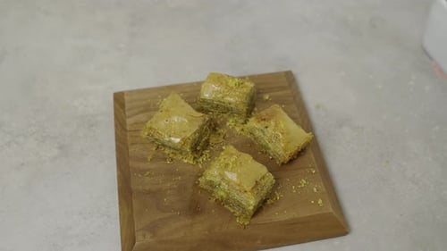 Verzierte Pistazien-Baklavastücke auf Holzplatte. Arabisches Gericht anrichten. Feines Essen.