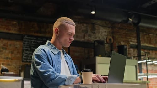 Man Working on Laptop in Coffee Shop