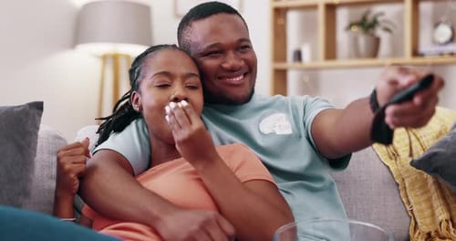 Young Couple Relaxing on Couch Watching TV