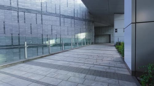 Empty modern urban walkway with glass barrier outdoors