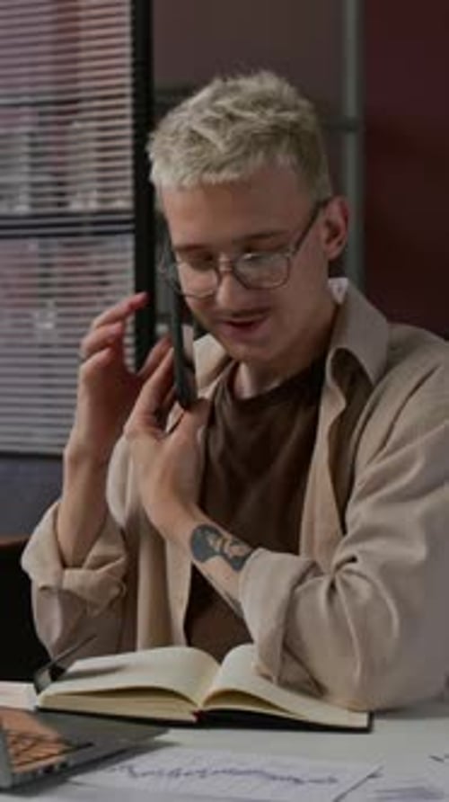 Young Adult on Phone Call and Taking Notes