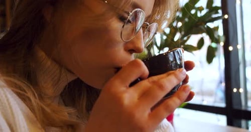 Closeup Footage of a Young Woman Drinking Coffee at a Cafe