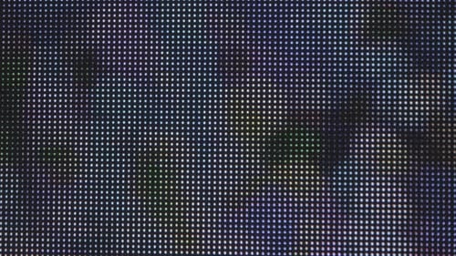 Extreme close-up shot: an LED grid display, featuring large illuminated dots that change color in an