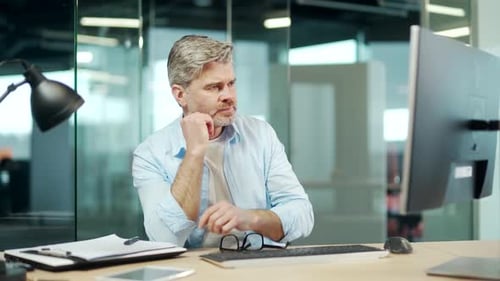 Portrait thoughtful employee. Concentrated serious male businessman working on pc computer at office