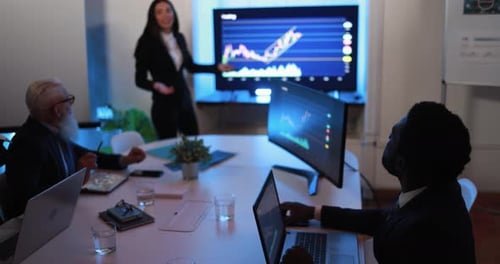 Business people discuss investment strategies in bank meeting room at night