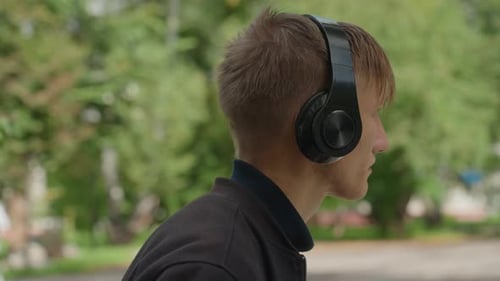 Young Man Listens Attentively Outside Concentrated Individual Strolling Through Park Outdoors Man