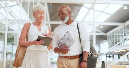 Colleagues Discussing Business While Walking in Modern Building