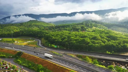 Aerial Drone Footage: Long Haul Semi Trucks Driving on the Busy Highway in the Rural Region of Ital