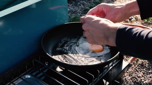 Breaking Three Eggs into a Pan on a Outdoors Cooking Set!
