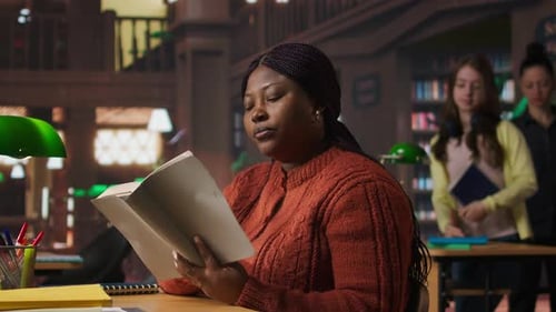 Woman Reads Book at Library Desk