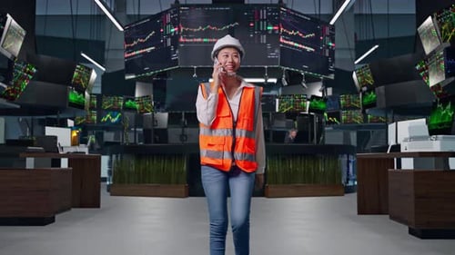 Asian Female Engineer Talking On Smartphone While Walking at Stock Market