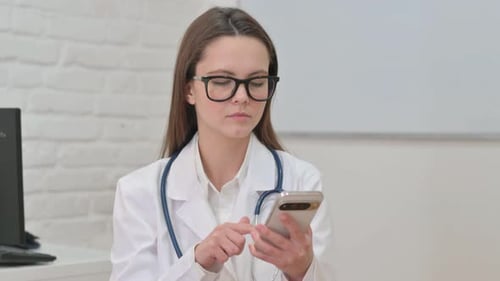 Female Doctor Using a Cell Phone in Office