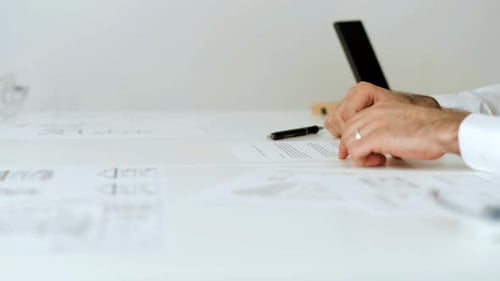 Man Signing Legal Documents at a White Table
