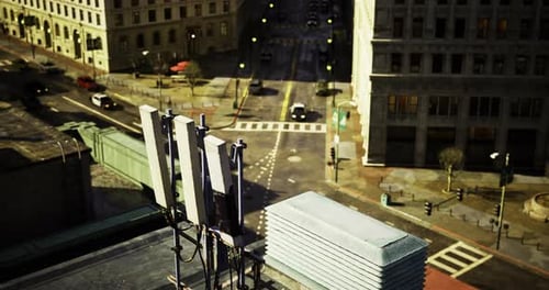 Urban Rooftop View Showcasing Cell Tower Equipment and Bustling Streets Below