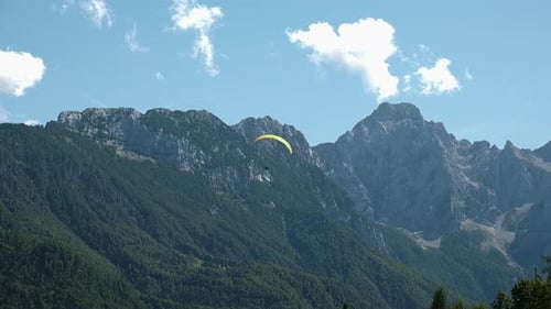 Fliegen in den Bergen, Gleitschirmfliegen in alpiner Landschaft, Freiheits- und Abenteuerkonzept, Adrenalin