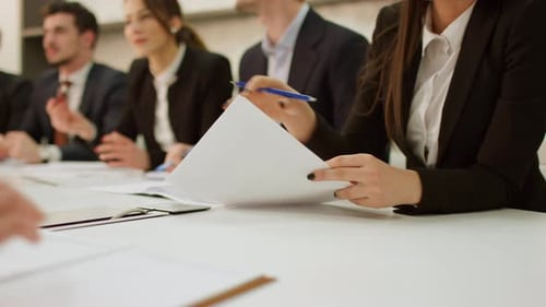 Close-Up View of Hands Handling Documents During Corporate Meeting