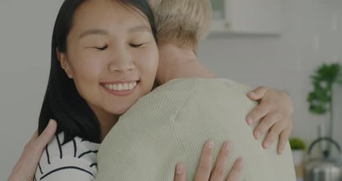 Slow Motion of Friendly Volunteer Hugging Retired Woman Smiling Talking to Pensioner in Apartment