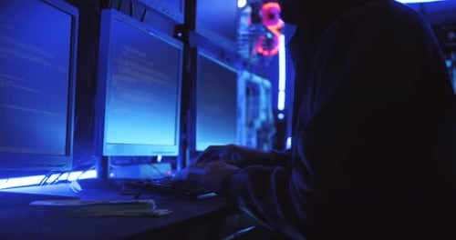 Ein männlicher Hacker benutzt einen Computer, um Daten zu hacken und Lösegeld von den Opfern zu verlangen.