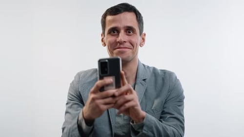 Man reacts to his smartphone, smiling