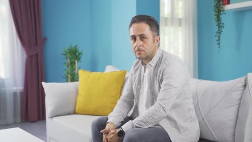 Man looking at camera with dull expression.