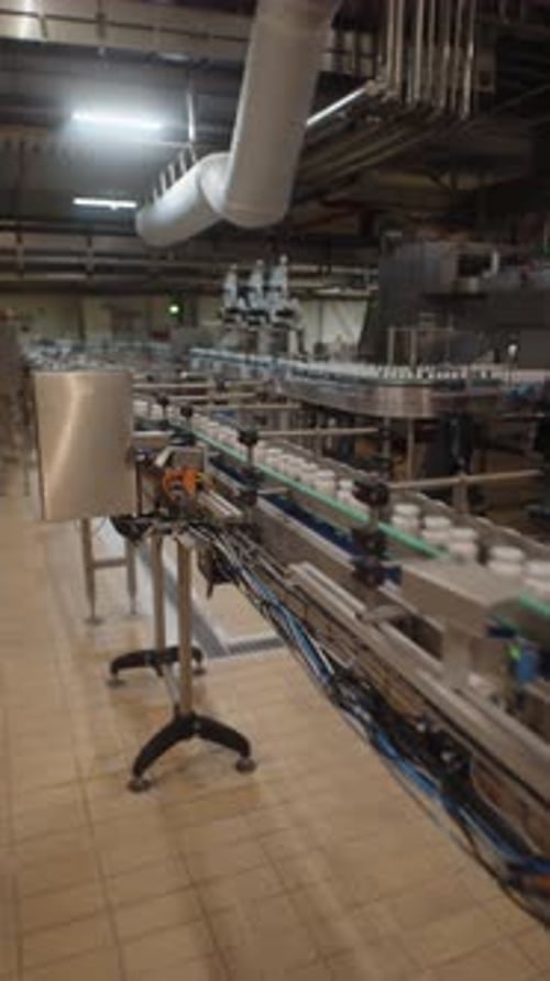 Plastic Jars with White Caps on Automated Conveyor Line
