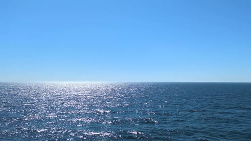 Funkelndes sonnenbeschienenes blaues Meerwasser, das unter klarem, hellem Himmel glitzert, Norwegen