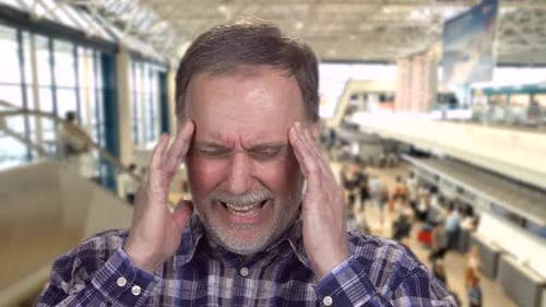 Man Experiencing a Headache at Terminal