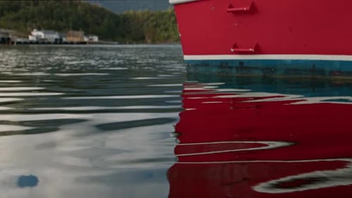 Red Boat Floating On Calm Waters Near A Dock