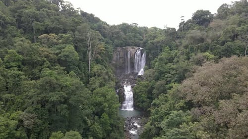 Lush Tropical Waterfall Cascading Down Through Jungle