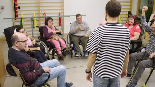 Adults Stretching Arms in Group Exercise Therapy Session