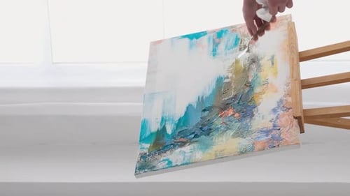 Artist Paints Masterpiece on Canvas with Easel Using Gestures and Paints