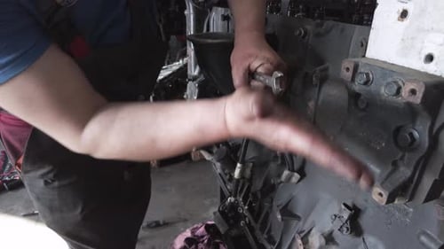Mechanic Repairing Large Industrial Engine with Wrench