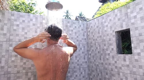 Man Washing Hair Outdoors in Tropical Shower
