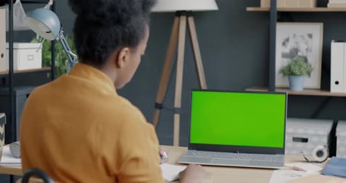 Back View of Female Employee Working with Laptop with Chroma Key Green Screen Writing Notes Sitting