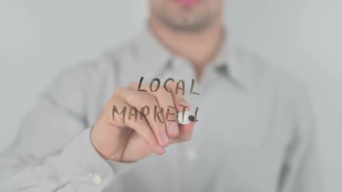 Young Adult Writing Local Marketing On Glass