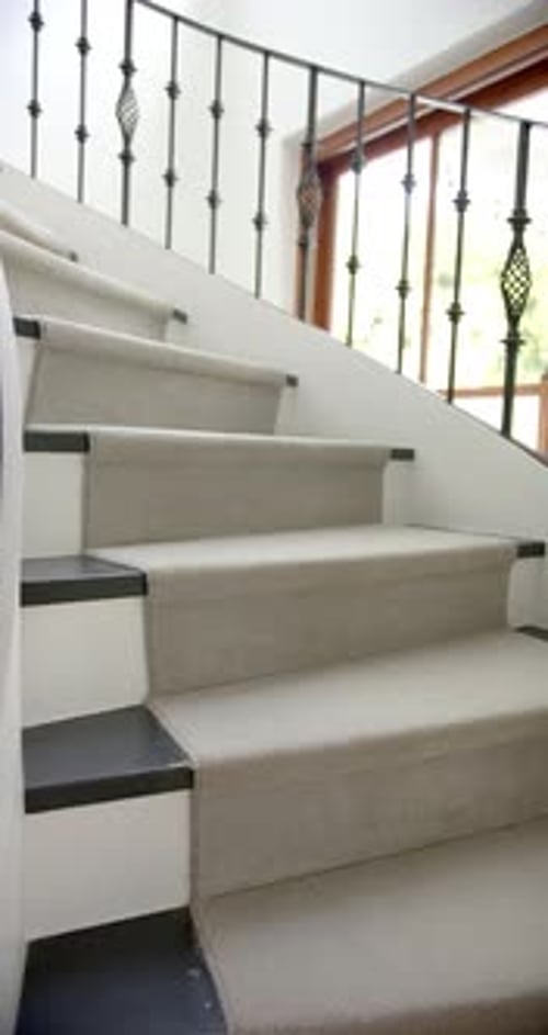 Vertical video of spiral staircase in hallway of luxury home, slow motion