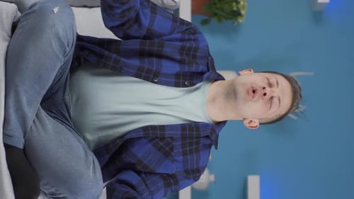 Young Man Performs Breathing Exercises on Couch