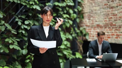 Businesswoman Dictates Voice Message in Modern Office