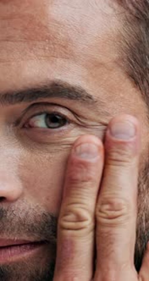 Man Applies Facial Serum in Close-Up Portrait