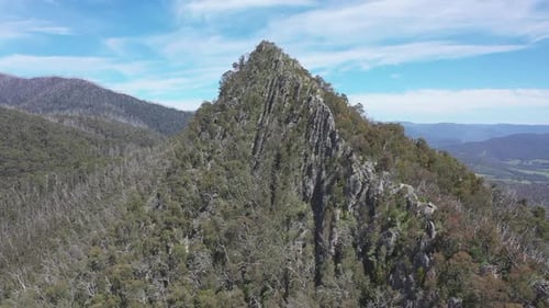 Aerial flies to knife edge summit ridge of Sugarloaf peak in Australia